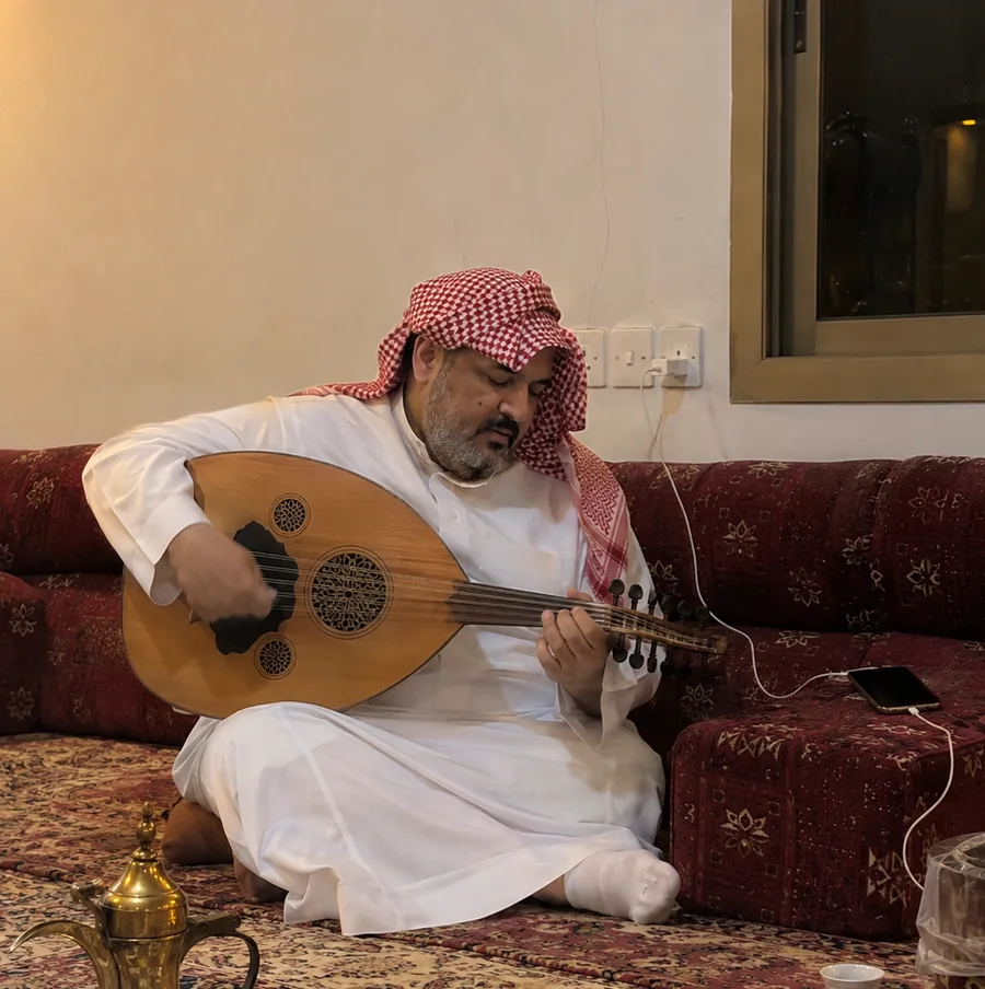 A Saudi man playing the oud in his home majlis, a phone photo